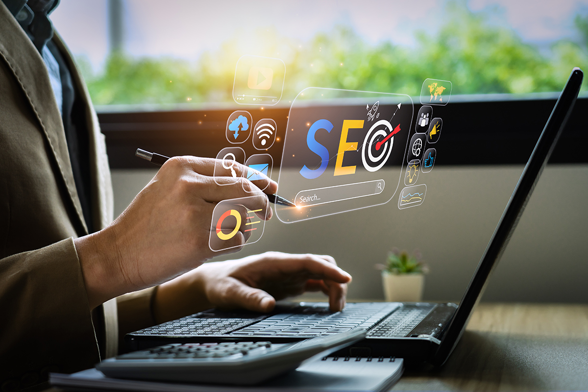 person on laptop working on seo with seo icons floating in the air